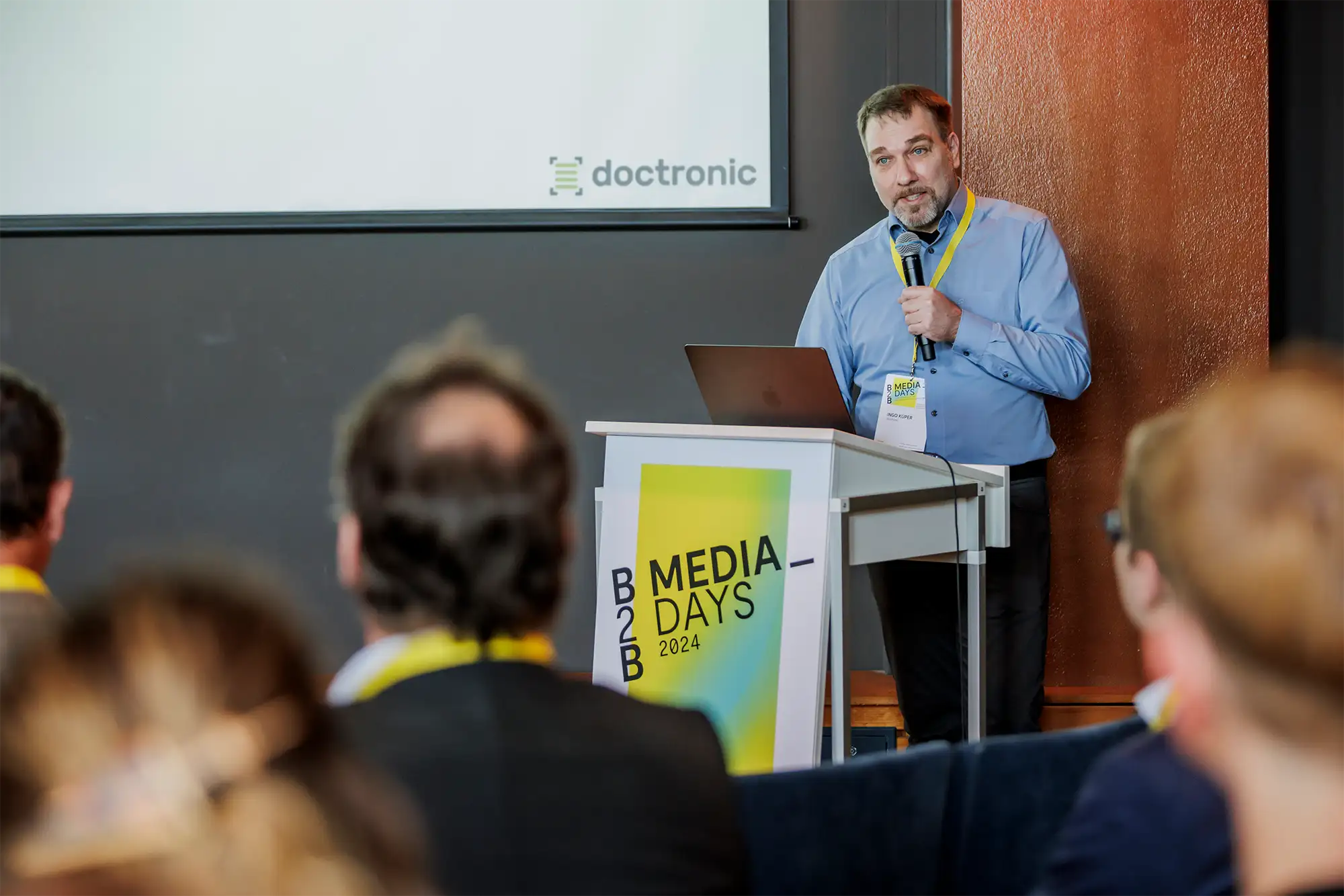 Ingo Küper steht am Rednerpult hält einen Vortrag auf den B2B Media Days