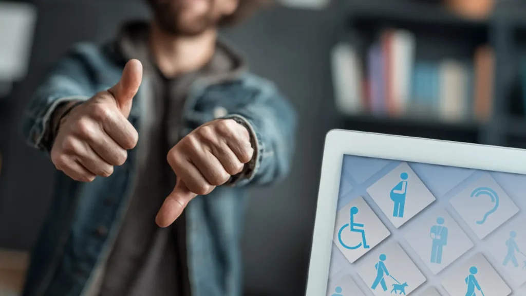 Daumen rauf und runter vor Tablet mit Barrierefrei-Symbolen