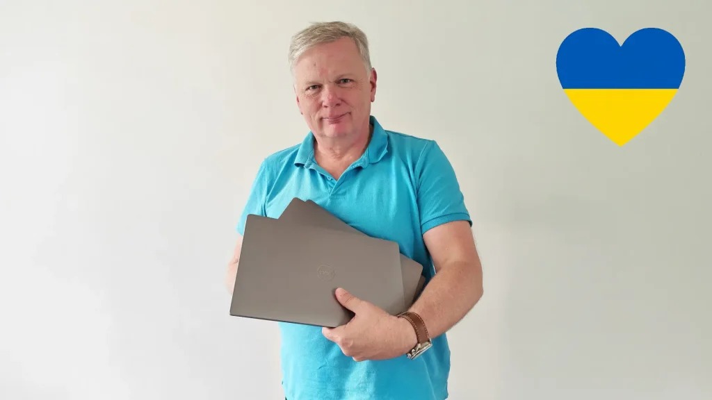 Mann mit drei silbernen Laptops im Arm