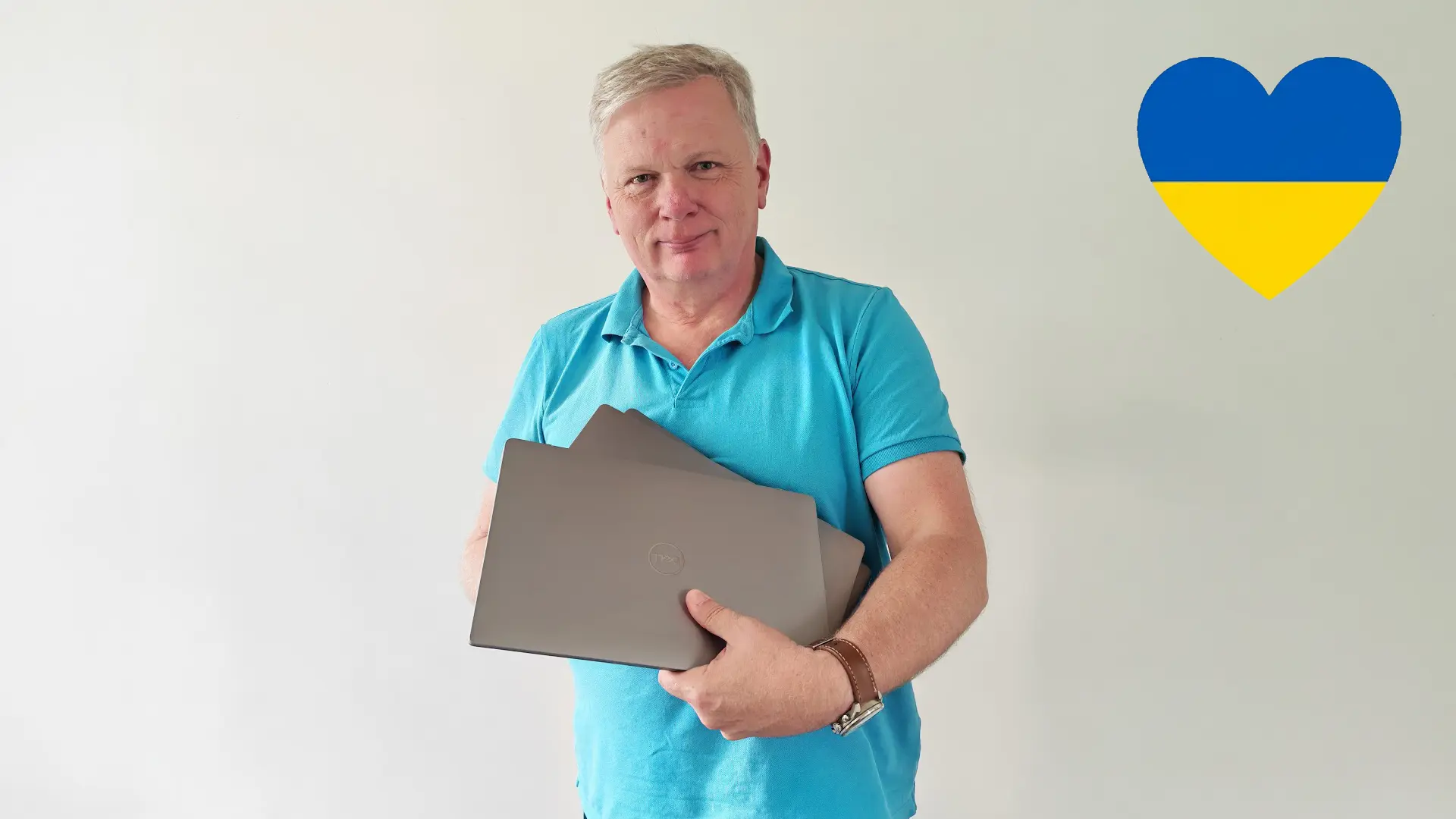 Mann mit drei silbernen Laptops im Arm